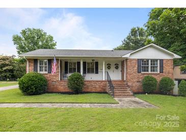 Charming brick home featuring a well-manicured lawn and inviting front porch with double door entry at 115 Fox Run Dr, Fort Mill, SC 29715