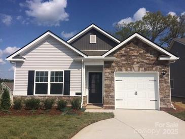 Charming one-story home with stone accents, covered entry, and a two-car garage, nestled on a well-maintained lot at 1242 Langston Ln, Salisbury, NC 28144