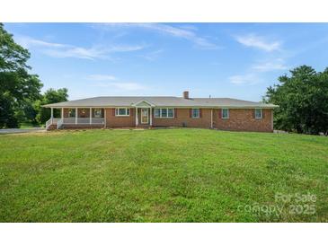 Charming brick home with a welcoming front porch and well-manicured lawn at 14411 Eastfield Rd, Huntersville, NC 28078