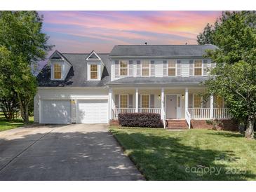 Charming two-story traditional home with a welcoming front porch, two-car garage, and landscaped front yard under a colorful sunset at 6603 Brenock Ln, Charlotte, NC 28269