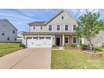 Charming two-story home featuring a two-car garage and a well-manicured front yard at 7079 Waterwheel Sw St, Concord, NC 28025
