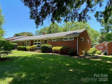Charming red brick ranch home with well-manicured lawn and mature landscaping at 1017 Andover Rd, Charlotte, NC 28211