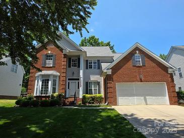 Charming two-story home featuring a brick facade, manicured lawn, and an attached two-car garage at 10607 Old Bridge Ln, Charlotte, NC 28269