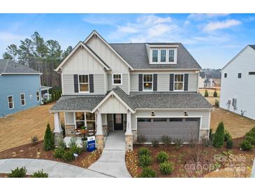 Stunning two-story home with a welcoming front porch, stone accents, manicured landscaping, and a two-car garage at 2192 Millennium Dr # 91, Lancaster, SC 29720