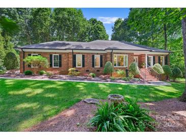 Charming brick home boasts a lush front yard with manicured landscaping and a welcoming entrance at 5008 Saddle Horn Trl, Weddington, NC 28104