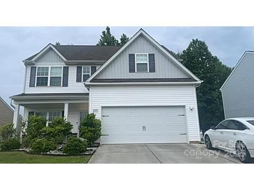 Charming two-story home with white siding and a two-car garage, nicely landscaped with lawn and bushes at 8330 Kneller St, Charlotte, NC 28215