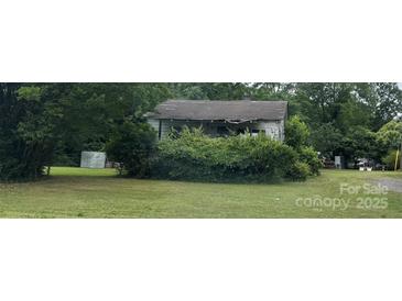 This property is an older home with a large yard surrounded by trees at 9924 Horton Rd, Charlotte, NC 28278