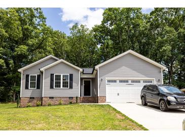 Charming single-story home with gray siding, brick accents, and a well-manicured lawn, shaded by mature trees in the front yard at 1005 8Th Sw Ave, Conover, NC 28613