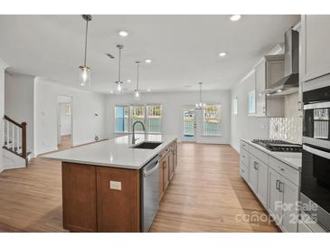 Bright, open kitchen features a large island with a stainless steel dishwasher and elegant pendant lighting at 1006 Kinship Dr # 120, Lancaster, SC 29720