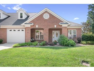 Charming brick home with well-manicured lawn and inviting front porch entrance with nice landscaping at 407 Knops Nob Rd, Mooresville, NC 28115