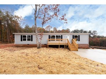 Charming single-story home featuring neutral siding, black shutters, and a wooden porch and steps at 716 Sharon Ln, Iron Station, NC 28080