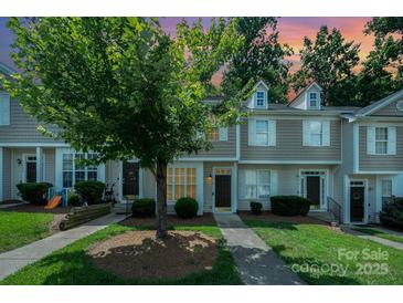 Charming townhome exterior with manicured lawn, mature tree, and sidewalks at 7518 Silver Arrow Dr, Charlotte, NC 28273