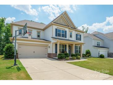 Charming two-story home with a well-manicured lawn and a basketball hoop over the garage at 10437 Paper Birch Dr, Charlotte, NC 28215
