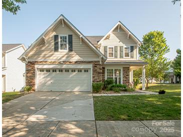Charming two-story home with a two-car garage, stone accents, and landscaped front yard at 1304 Hammond Dr, Matthews, NC 28104