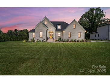 Charming brick home with a manicured lawn and professionally landscaped yard; a welcoming sight for prospective buyers at 19 Berea Baptist Church Rd, Stanfield, NC 28163