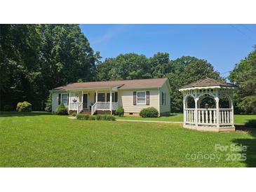Charming single-story home featuring a covered porch, well-manicured lawn, and a quaint gazebo at 233 Hicks Rd, Statesville, NC 28625
