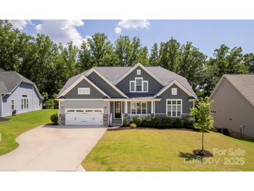 Charming gray home featuring a two-car garage, manicured lawn, and classic architectural details at 252 Broadleaf Dr, Denver, NC 28037