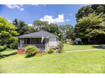 Charming one-story home with a screened front porch and a spacious, green lawn at 3419 Boat Club Rd, Belmont, NC 28012