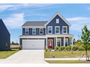 Charming two-story home with a well-maintained lawn, a two-car garage, and a welcoming red front door at 1516 Respect Nw St, Concord, NC 28027