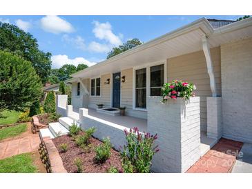 Charming home featuring a welcoming front porch with flower boxes and a freshly landscaped garden bed at 172 Wildwood Loop, Statesville, NC 28625