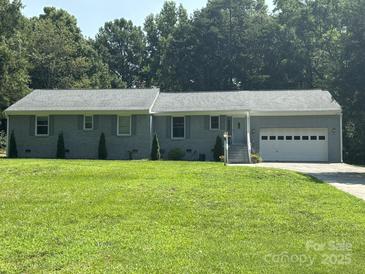 Charming single-story home with brick exterior, well-manicured lawn, and attached garage at 3711 Davis Dr, Charlotte, NC 28270