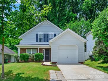 Charming two-story home with well-manicured lawn, garage, and a welcoming facade with lush green trees at 3830 Brookchase Ln, Charlotte, NC 28205