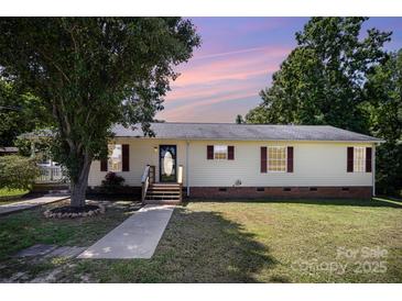 Charming single-story home with light yellow siding and classic red shutters, enhanced by mature trees and a manicured lawn at 508 Bridgestone Ln, Rock Hill, SC 29730