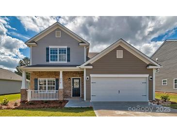Charming two-story home showcasing a well-manicured lawn and an inviting front porch at 513 Jacobus Ln, Monroe, NC 28112