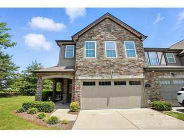Charming two-story townhome featuring a stone facade, covered entryway, and attached two-car garage at 809 Ayrshire Ave, Fort Mill, SC 29708