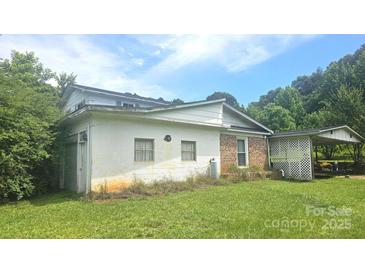 Side view of a two story home featuring brick and white painted exteriors and large front yard at 11056 Us Highway 52 N Hwy, Wadesboro, NC 28170