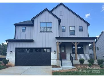 Beautiful new construction home with gray siding, black trim, a front porch, and a two-car garage at 15012 Brownleigh Ln # 30, Huntersville, NC 28078
