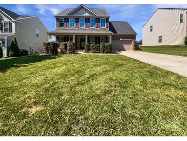 Traditional two-story home featuring manicured lawn, brick facade, covered porch and attached garage at 5013 Crandon Rd, Fort Mill, SC 29707