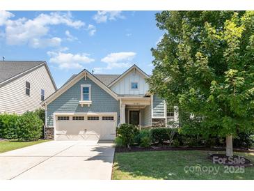Charming home featuring a manicured front yard, attached two-car garage, and craftsman-style architectural details at 11225 Black Brant Ln, Charlotte, NC 28278