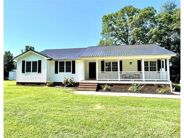 Charming one-story home featuring a welcoming front porch, green lawn and a durable metal roof at 147 Dutchman Rd, Harmony, NC 28634