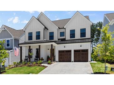 Beautiful two-story home with white siding, dark trim, covered porch, and attached two car garage at 18027 Wilbanks Dr, Charlotte, NC 28278