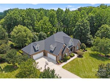 Beautiful brick home with a three-car garage and expansive driveway and mature landscaping at 2818 Levinfield Ct, Lincolnton, NC 28092
