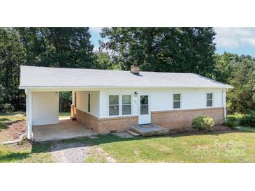 Inviting home with charming architectural details, a covered carport, and a well-maintained yard at 326 Gorrell St, Shelby, NC 28152