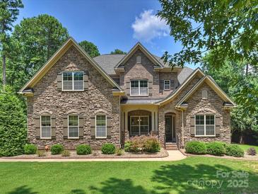Beautiful stone-clad house with a manicured lawn and mature trees showcasing its curb appeal at 631 May Green Dr, Clover, SC 29710