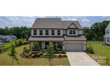 Charming two-story home with a landscaped front yard, covered porch, and two-car garage at 7058 Cloer Ct, Charlotte, NC 28214