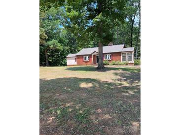 Charming one-story brick home featuring a spacious front yard and mature trees at 11204 Williams Rd, Mint Hill, NC 28227