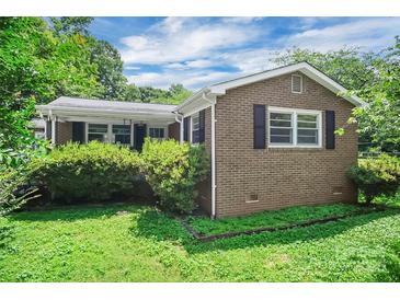 Charming brick home featuring black shutters and a lush green lawn at 2215 Hodgin St, Gastonia, NC 28056