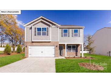 Charming two-story home with a brick and siding exterior, attached garage, and well-manicured lawn at 119 Rustling Waters Dr, Mooresville, NC 28117