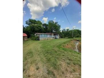 Charming home exterior with blue siding, a front porch, and a neatly mowed lawn at 3913 Stough Sw Rd, Concord, NC 28027