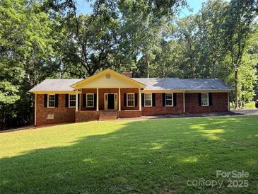 Charming single-story brick home featuring a welcoming front porch and lush green lawn at 3943 Peggy Ln, Mint Hill, NC 28227