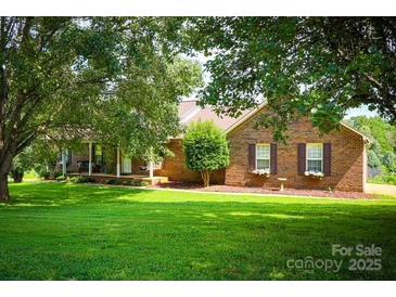 Charming brick home featuring a well-manicured front lawn, mature trees, and inviting curb appeal at 5172 Butner Dr, Hickory, NC 28602