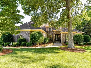 Charming brick home featuring mature landscaping, a manicured lawn, and elegant architectural details at 9000 Whirlaway Ln, Waxhaw, NC 28173