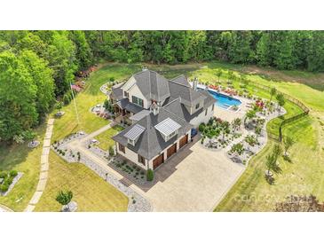 Expansive estate with a luxurious pool, meticulously landscaped grounds, and a private three-car garage at 1430 Rosehill Dr, Waxhaw, NC 28173