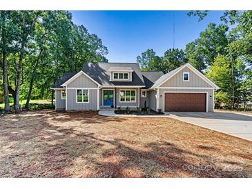 Charming single-story home with a modern design, blue door, gray siding, and a well-manicured lawn at 252 Teeter Rd, Mooresville, NC 28115