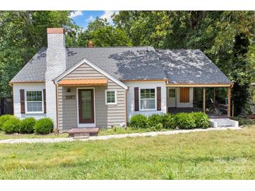 Charming bungalow-style home with brick chimney, covered front porch, and mature landscaping at 308 Davis Park Rd, Gastonia, NC 28052
