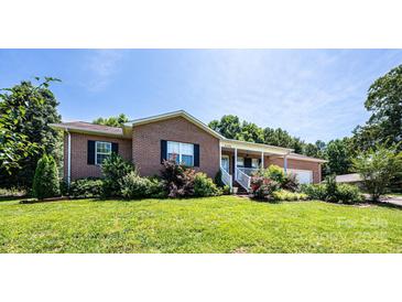Charming brick home with a covered front porch, well-maintained lawn, and established landscaping at 4128 River Run Cir, Hickory, NC 28602